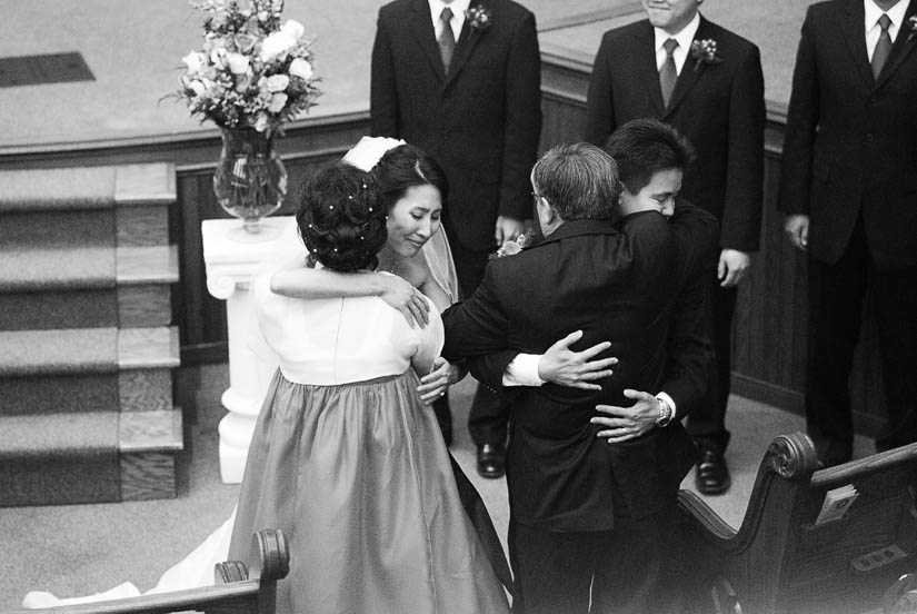 bride and groom hug parents of the bride
