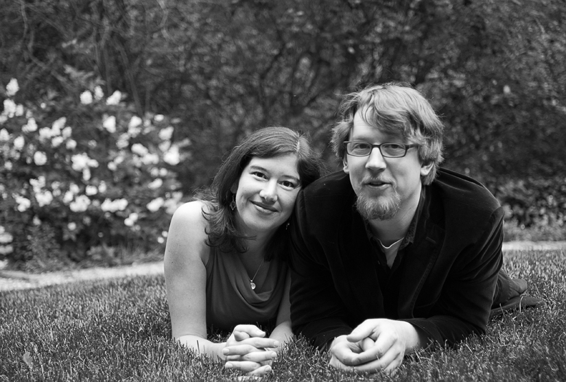 cute couple lying on the grass in black and white