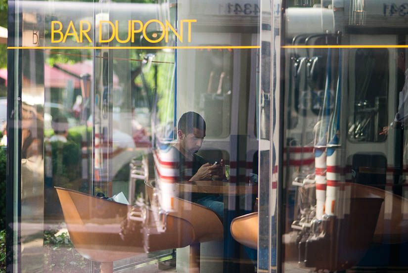 reflections and a guy on blackberry at bar dupont