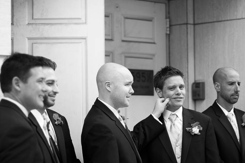black and white of groom with pinched cheek