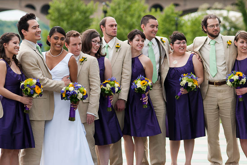 wedding party with linen suits, green ties and purple dresses