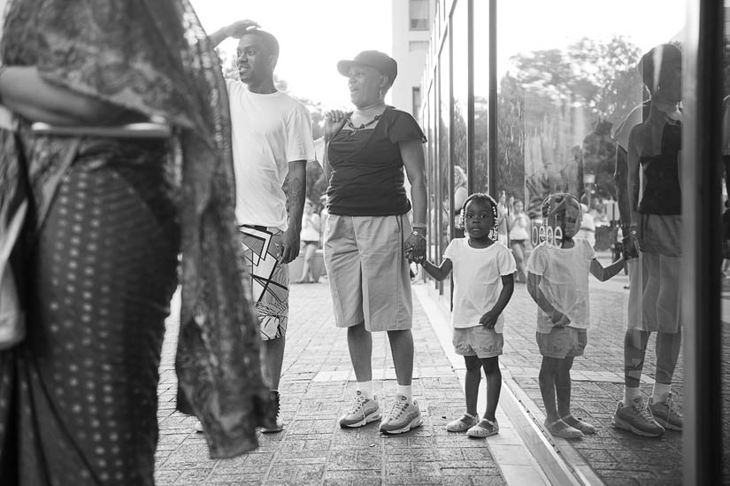 little girl watches groom on horse