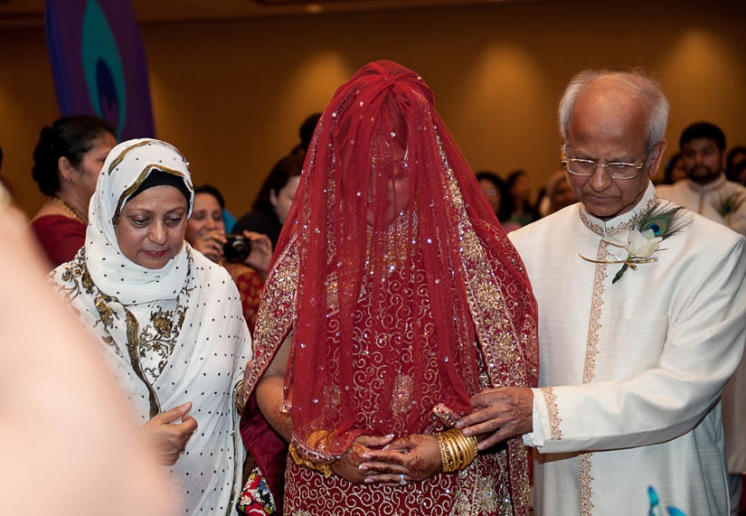 veiled bride walks to stage with parents