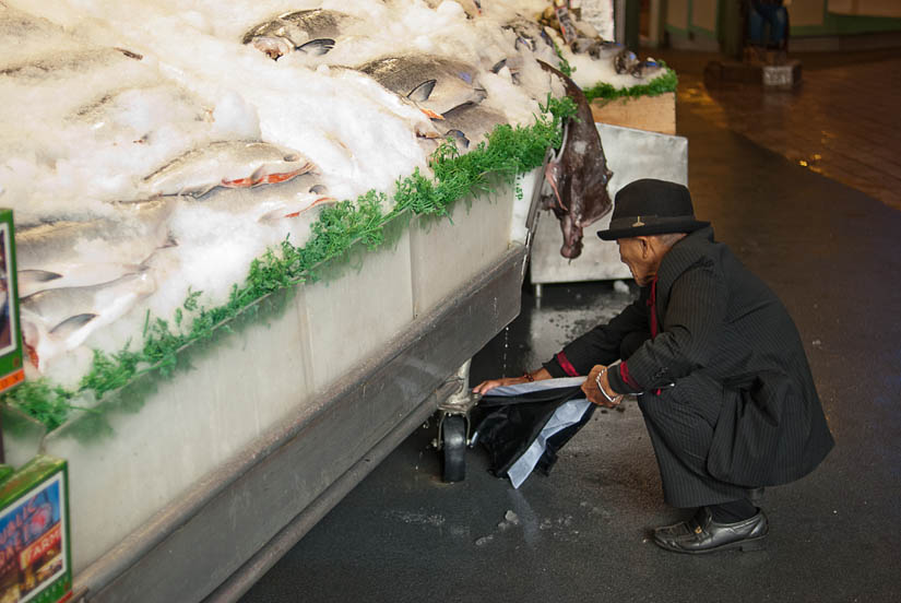 guy cleaning umbrella with fish water