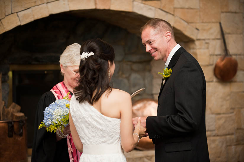 groom smiles during wedding ceremony at la ferme