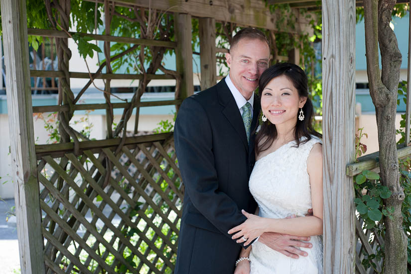 bride and groom under the trellis at la ferme restaurant