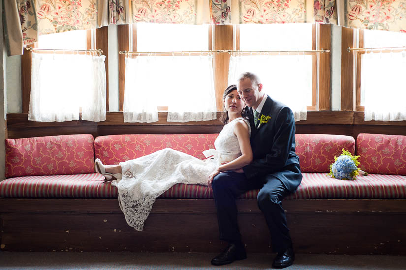 bride and groom on french couch upstairs at la ferme