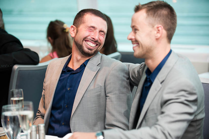 grooms laughing during speeches