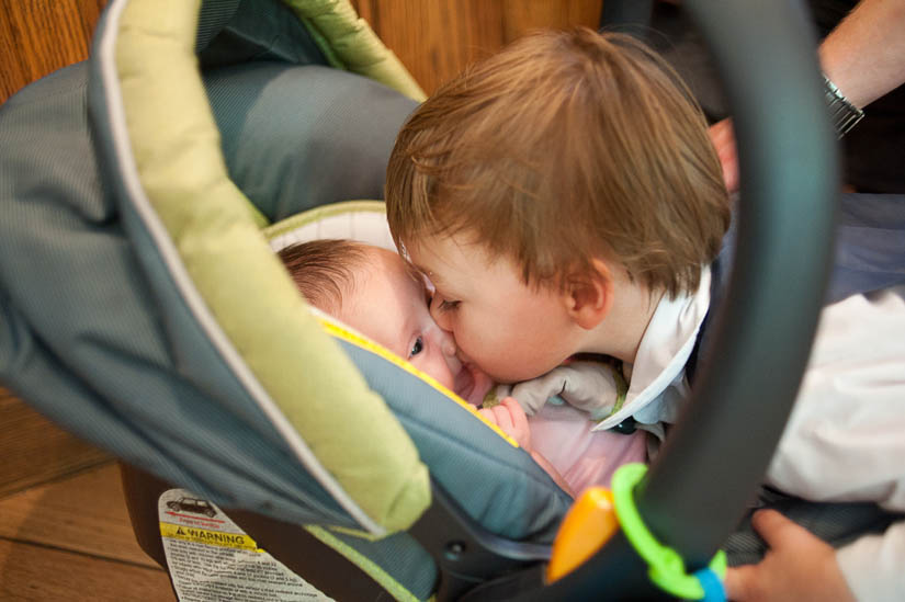 kid kisses baby at wedding reception