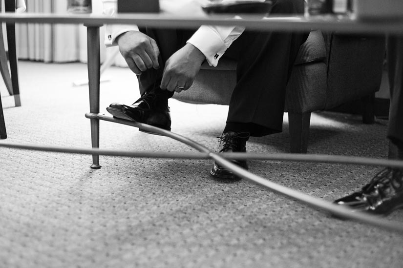 groomsman tying shoe