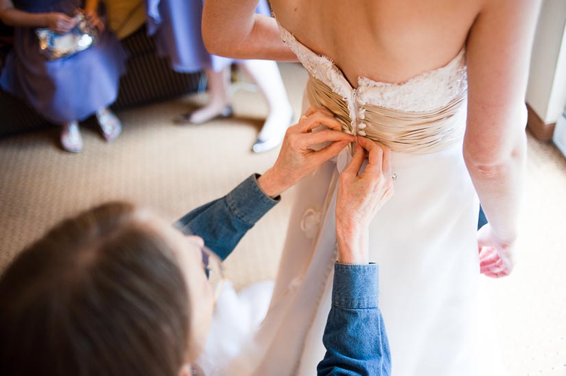 mom tying her daughter's wedding dress