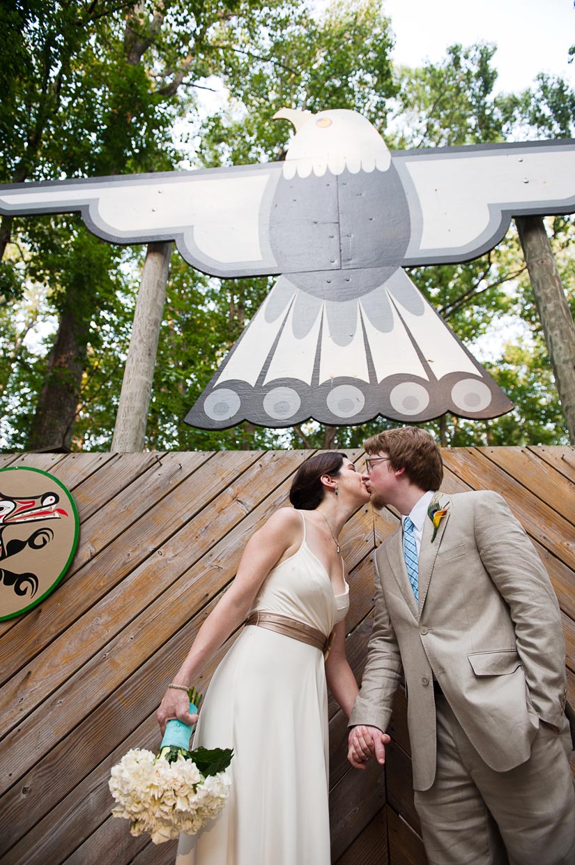 bride and groom kissing under giant eagle