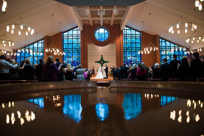 wedding ceremony at catholic church with baptismal font