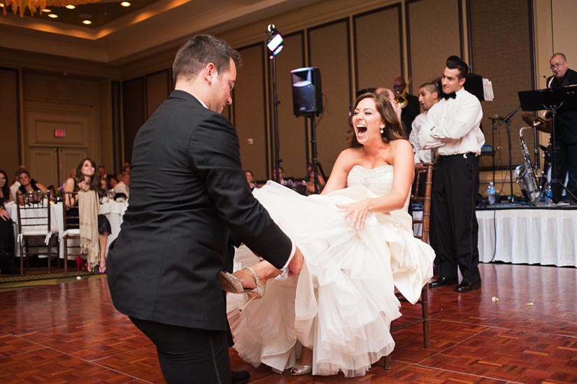 bride laughing during garter toss