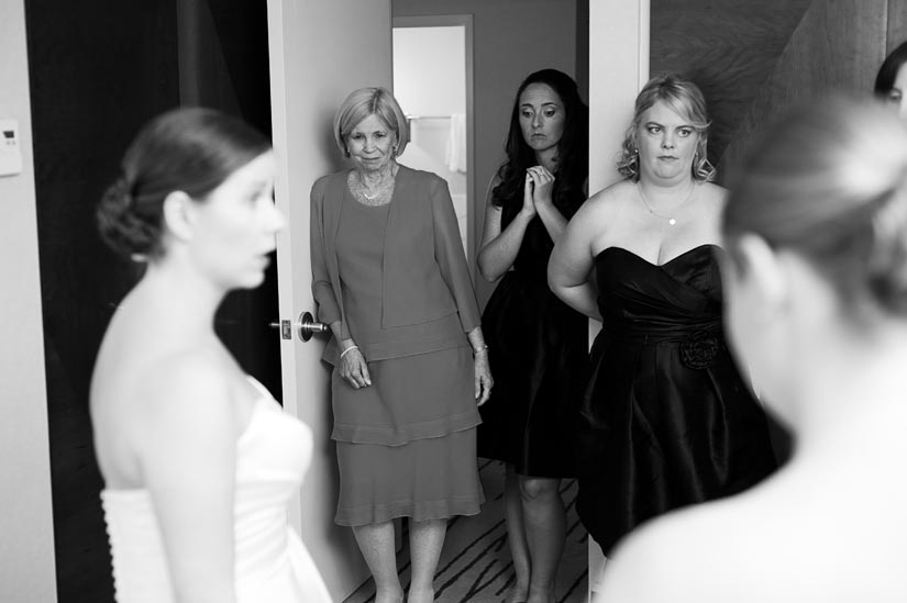 mother of the bride watches her daughter get ready