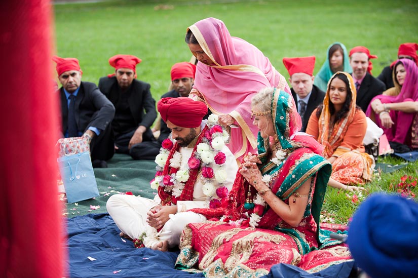 mother of the groom places a garland on him