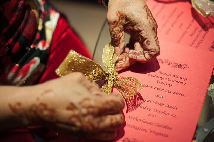 mother of the groom ties a bow on a program