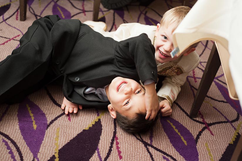 little boys playing on the floor at the wedding reception