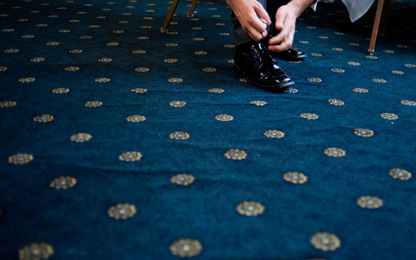 groom ties his shoes on carpet