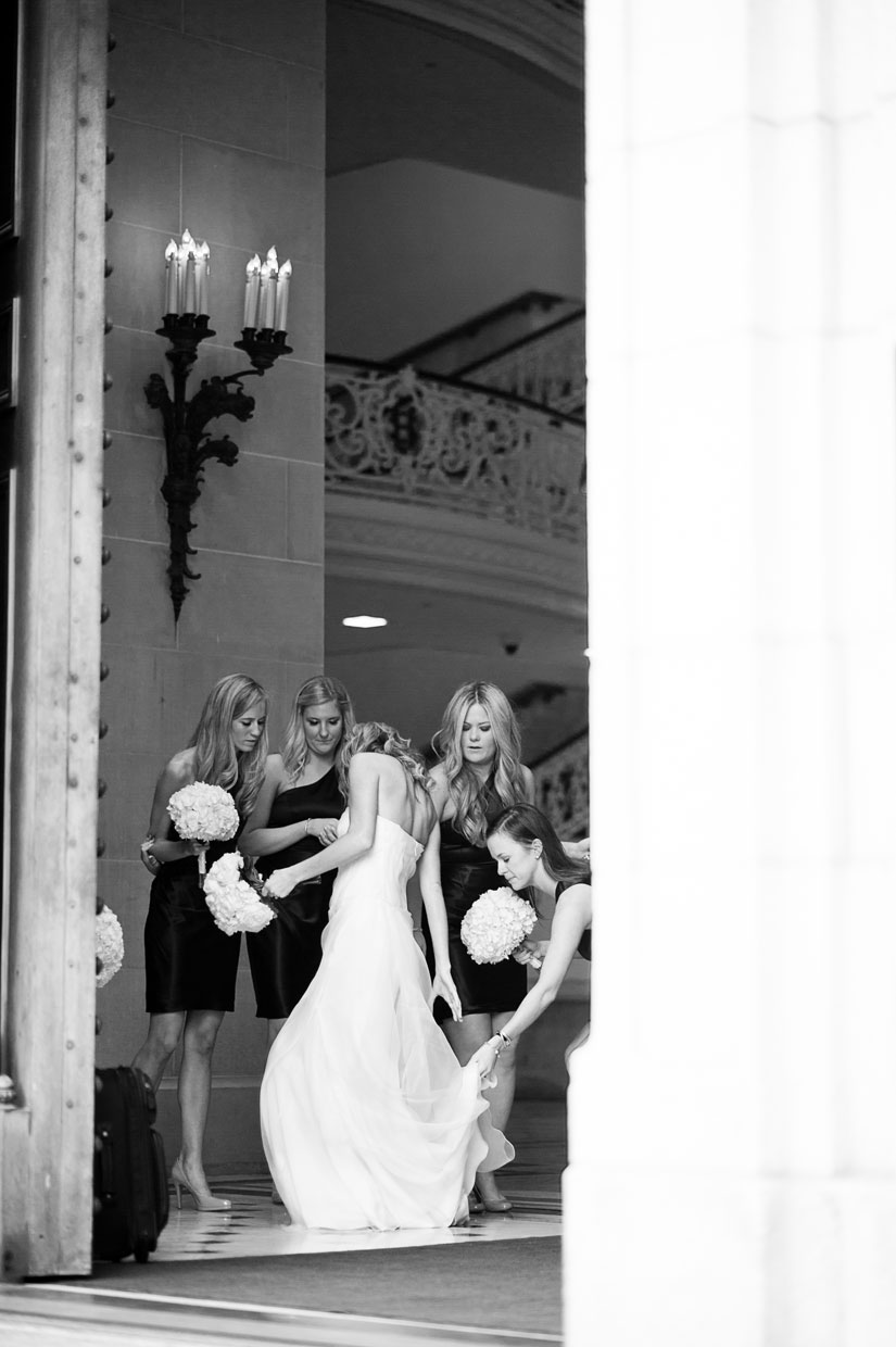 bridesmaids helping bride with wedding dress