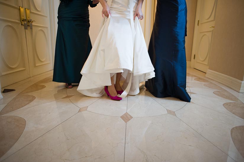 bride puts on her shoes in mayflower suite