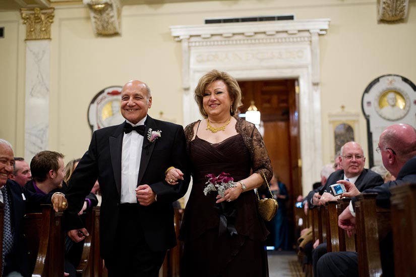 parents of the groom walk down the aisle