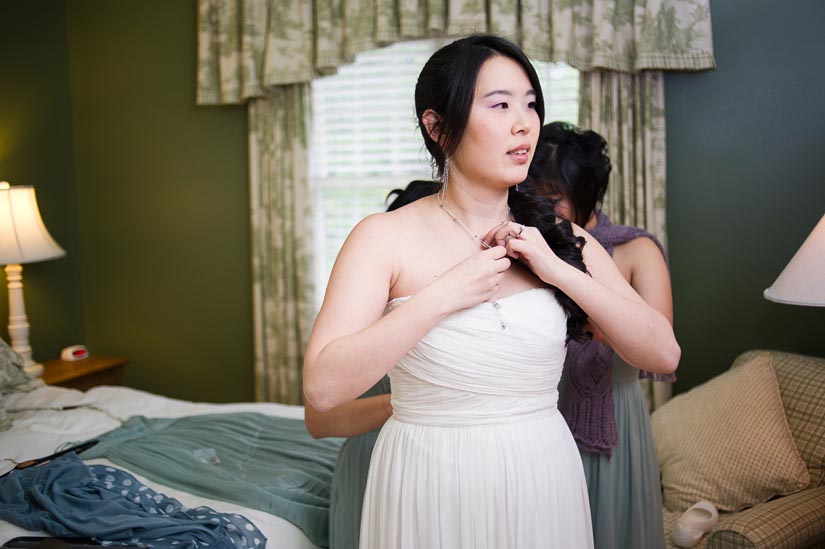 bride putting on her dress at the oaks