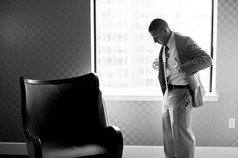 groom putting on jacket at hotel monaco