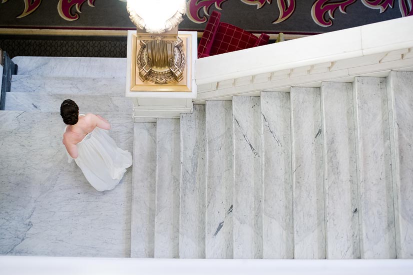 bride going down hotel monaco stairs in baltimore