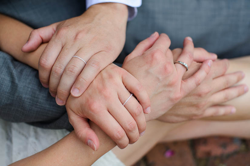 hands clasped with wedding strings