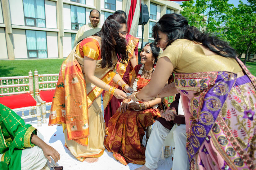 sisters participate in indian wedding ceremony