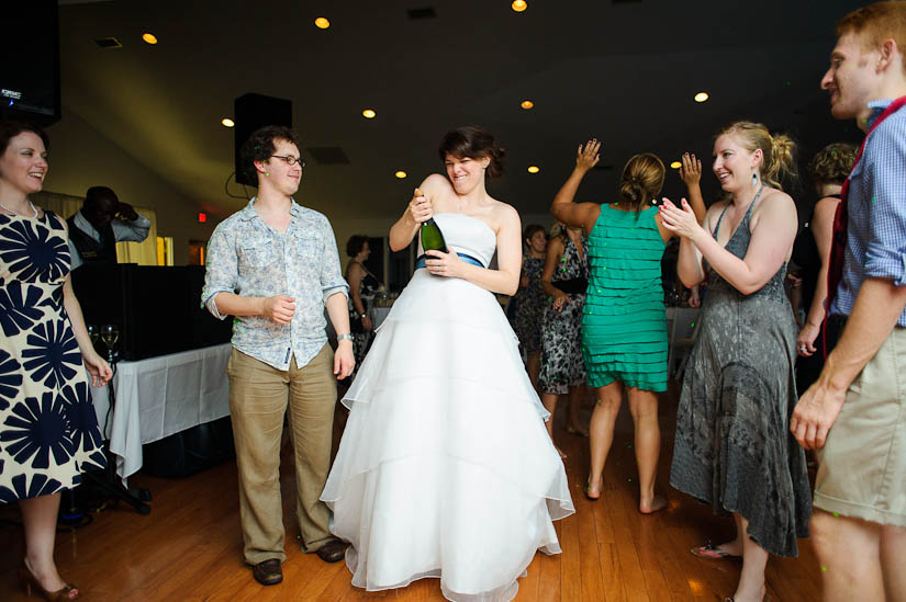 bride opens a bottle of champagne