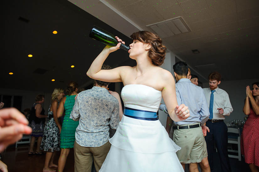 bride downs a bottle of champagne