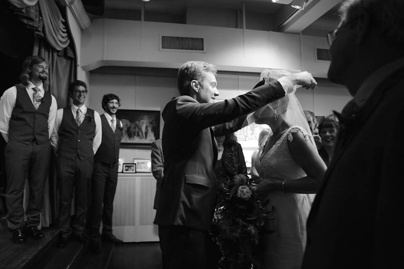 groom lifts veil during wedding ceremony