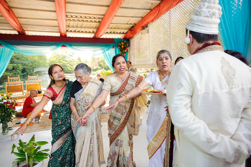 female relatives pointing at garden falls indian wedding