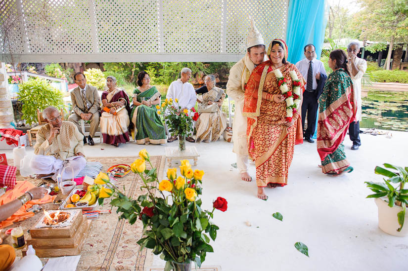 bride and groom standing on leaves at garden falls indian wedding