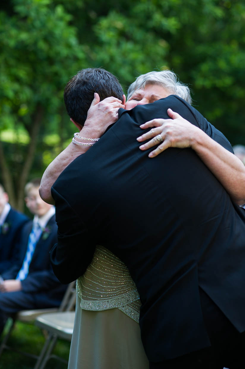 mother hugging her son during a st. francis hall wedding