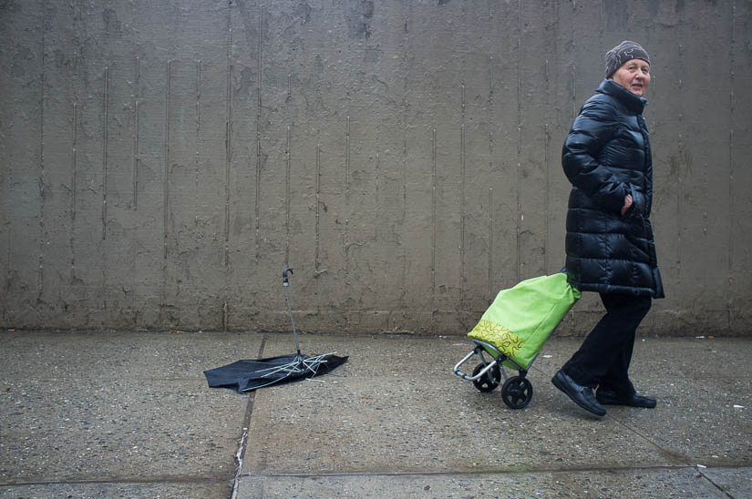 lady walking by a broken umbrella