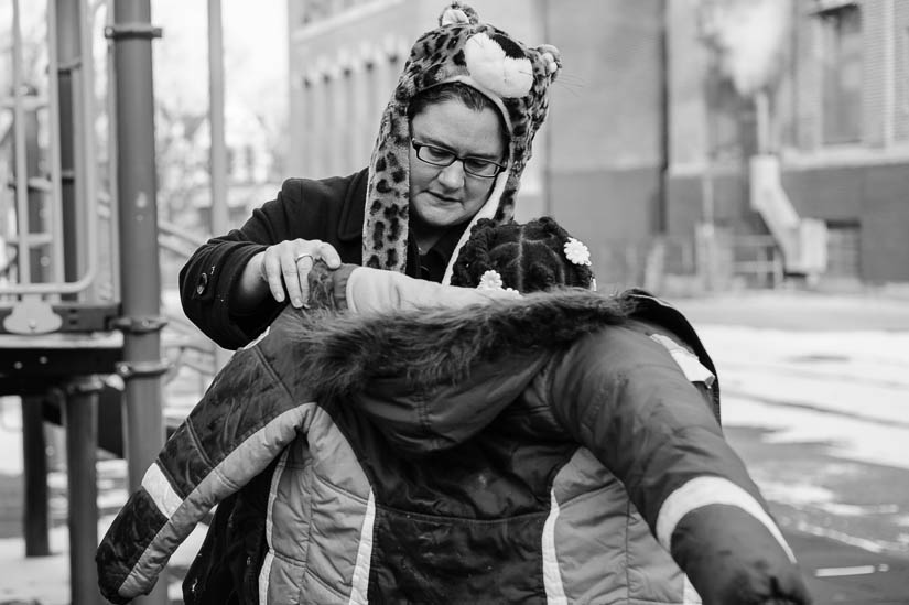 mom helping daughter into jacket