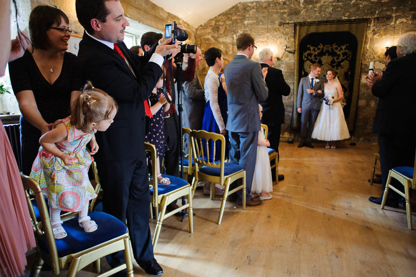 little girl looking at the bride and groom at danby castle wedding