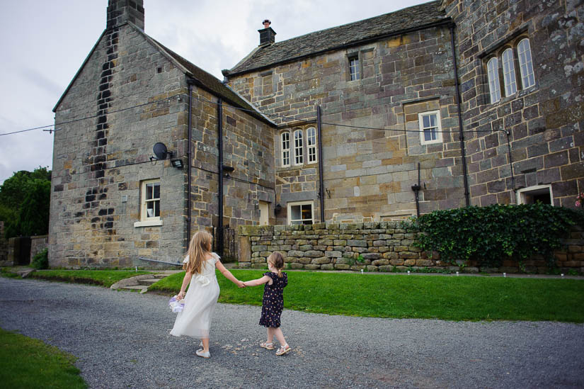 little girls walking hand-in-hand at danby castle wedding