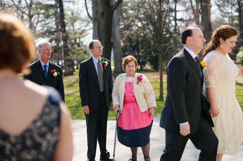 mom looking fondly on as son walks to wedding