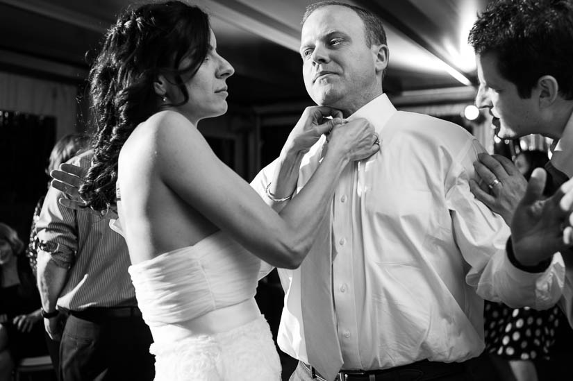 taking off his tie at flying bridge wedding