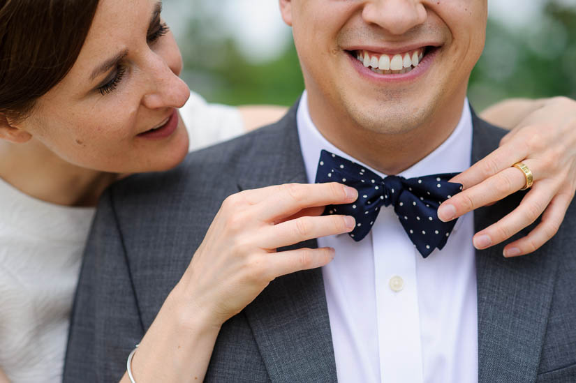 adjusting his tie during wedding portraits