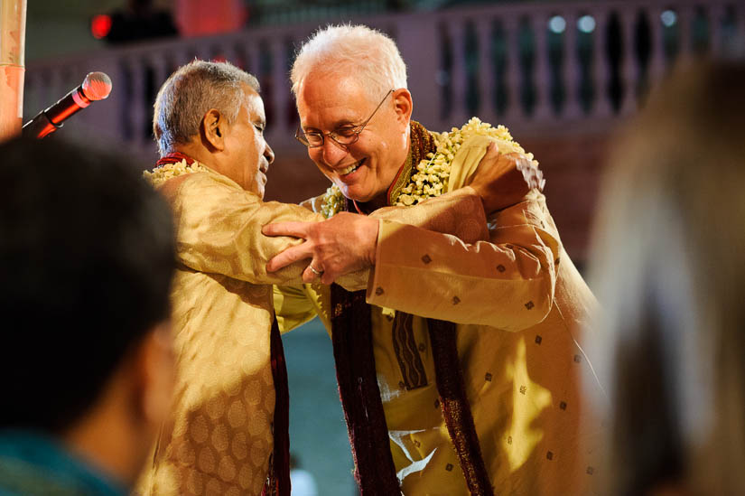 fathers hugging at hindu wedding at national museum for women in the arts