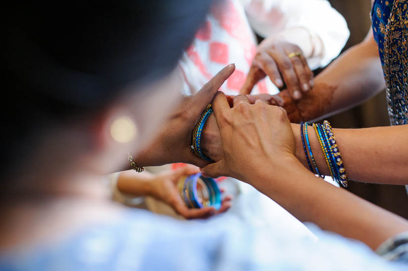 bride puts on bangles for hindu wedding