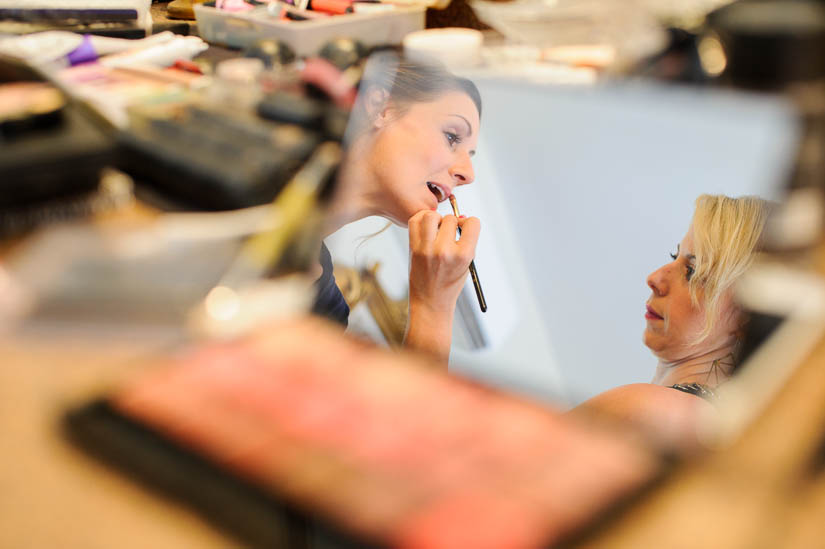 bride getting her makeup done at historic rosemont manor wedding