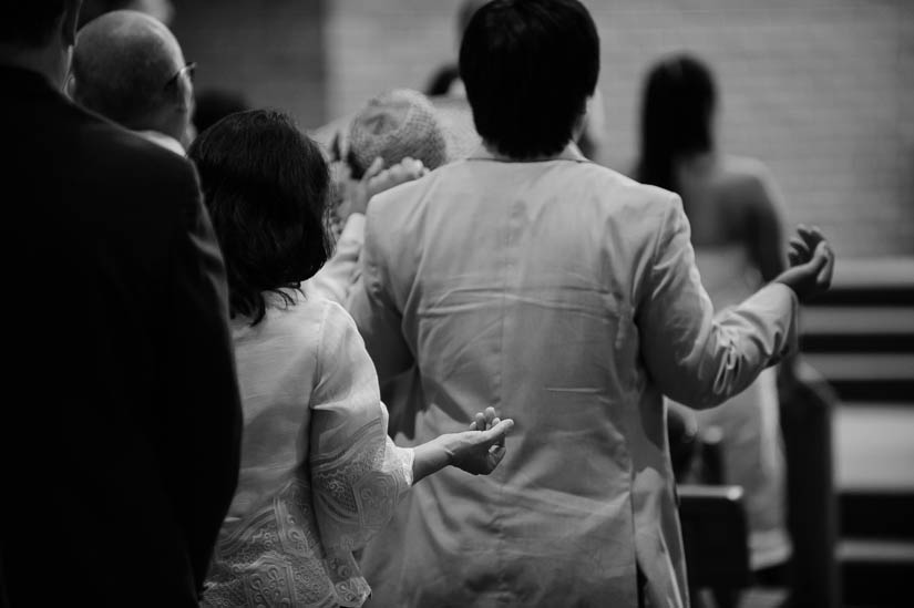 guests praying during wedding ceremony