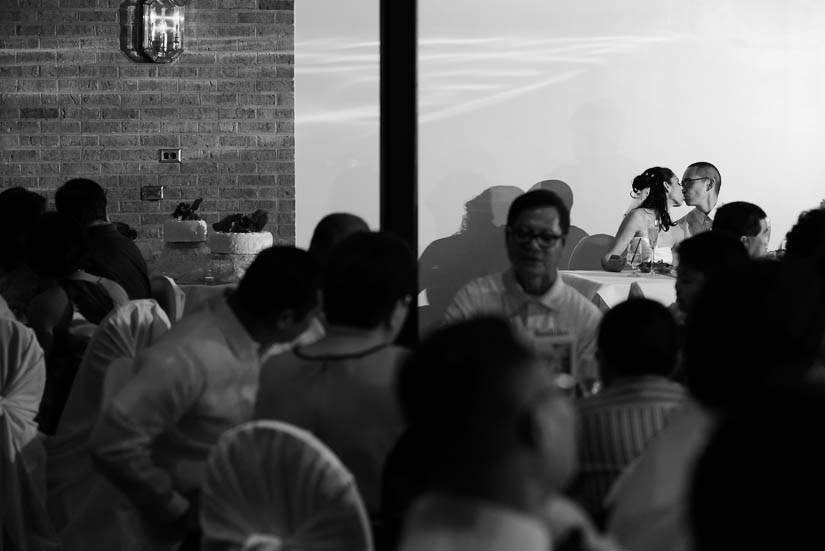 bride and groom share a kiss during the dinner