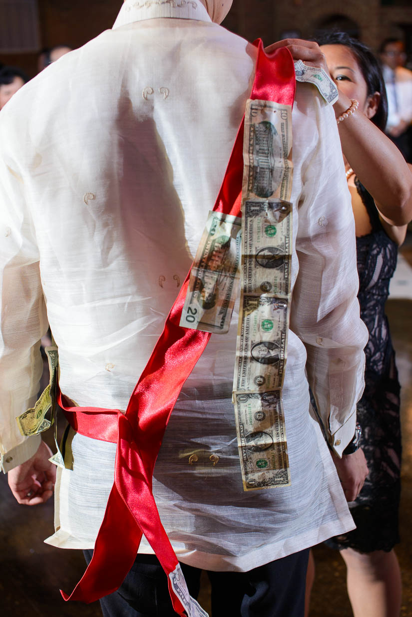 chain of bills hanging from groom during money dance